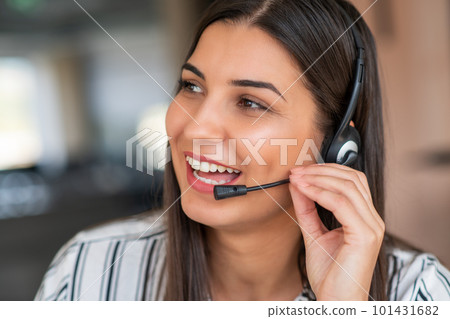 Young friendly operator woman agent with headsets working in a call centre. Young friendly operator woman agent with headsets working in a call centre. 101431682