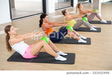 Women doing crunhces with pilates balls 101432440