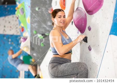 Young woman practicing rock climbing on climbing wall Young woman practicing rock climbing on climbing wall 101432454