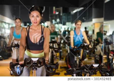 Woman on stationary bike workout in gym Woman on stationary bike workout in gym 101432465