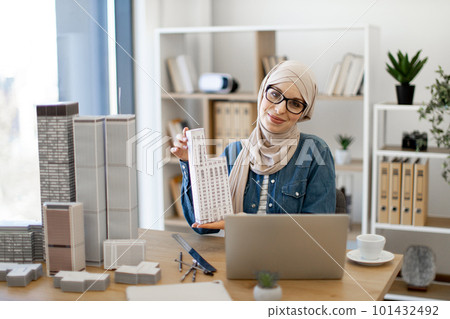 Lady posing with architectural model at office desk Lady posing with architectural model at office desk 101432492