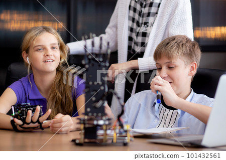 Caucasian two teenager students learning robotic arm in classroom together. Caucasian two teenager students learning robotic arm in classroom together. 101432561