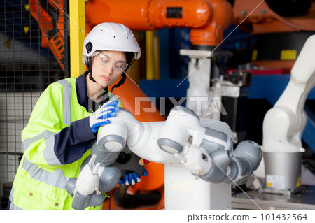 Young engineer woman checking and maintenance machine robot arms. Young engineer woman checking and maintenance machine robot arms. 101432564