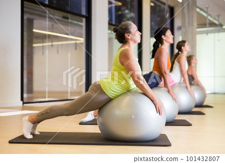Women during group workout with fitness ball at gym 101432807