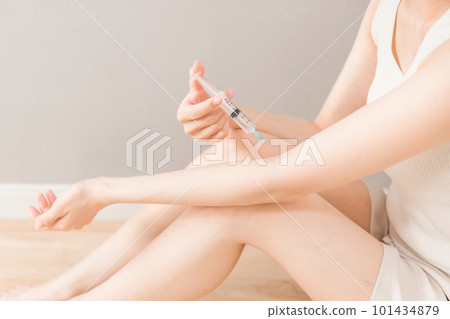 一名婦女用注射器用興奮劑、藥物或非法藥物擊打她的手臂 101434879