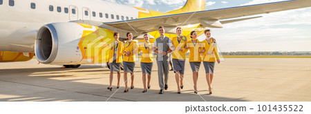 Cheerful aircrew walking down airfield under blue sky Cheerful aircrew walking down airfield under blue sky 101435522