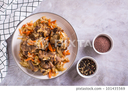 Stewed oxtail with carrots and onions on a plate on the table top view Stewed oxtail with carrots and onions on a plate on the table top view 101435569