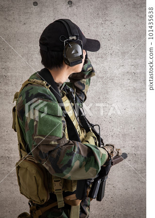 A man in camouflage uniform holding a gun camouflage A man in camouflage uniform holding a gun camouflage 101435638