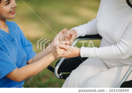 Elderly asian senior woman on wheelchair with Asian careful caregiver. Nursing home hospital garden concept. in sun light 101436044