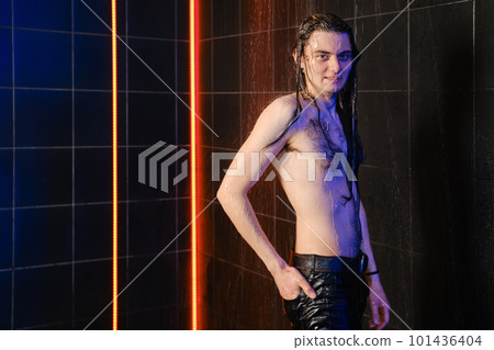 Cheerful man with long hair posing under water jets in shower Cheerful man with long hair posing under water jets in shower 101436404