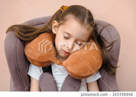 Preschool girl fastened sleeping in a car seat with travel pillow Preschool girl fastened sleeping in a car seat with travel pillow 101436898