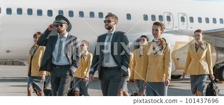 Pilots and flight attendants walking down airfield after landing Pilots and flight attendants walking down airfield after landing 101437696