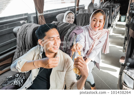 passengers sharing snacks with other while road trip on the bus 101438264