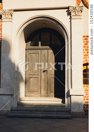 Old vintage wooden door. Gorgeous wooden door in the streets of Olsztyn Poland. Ancient on around arch with stone wall 101438586