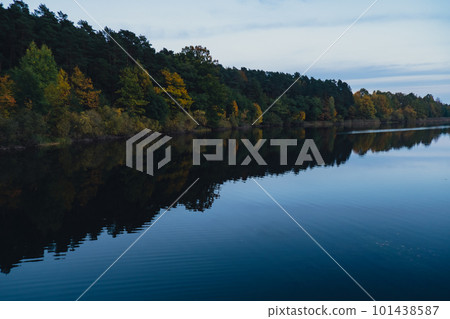 Stunningly beautiful lake in the golden autumn season. Magical multi-color reflection with light ripples on the surface of the water fall evening. Autumn scenery Colorful vibrant autumn forest Stunningly beautiful lake in the golden autumn season. Magical multi-color reflection with light ripples on the surface of the water fall evening. Autumn scenery Colorful vibrant autumn forest 101438587