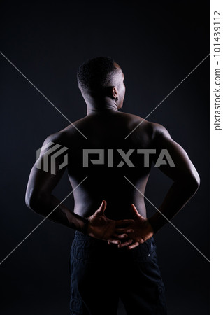 One young african muscular build man standing topless silhouette isolated on black background One young african muscular build man standing topless silhouette isolated on black background 101439112