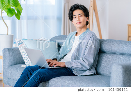 在房間裡用電腦工作的年輕人 在房間裡用電腦工作的年輕人 101439131