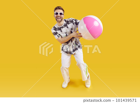 Smiling happy guy in sunglasses holding inflatable sea ball Smiling happy guy in sunglasses holding inflatable sea ball 101439571