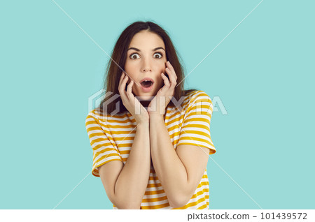 Woman looking at you with surprised and shocked facial expression isolated on light blue background. Woman looking at you with surprised and shocked facial expression isolated on light blue background. 101439572