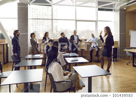 Team of people listening to their teacher during business training class in office Team of people listening to their teacher during business training class in office 101439583