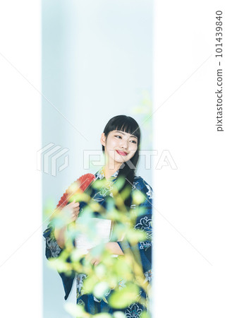 A woman wearing a yukata and holding a folding fan 101439840