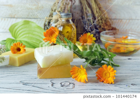 Calendula flowers, soap, oils and tinctures, on a wooden background, natural ingredients Calendula flowers, soap, oils and tinctures, on a wooden background, natural ingredients 101440174