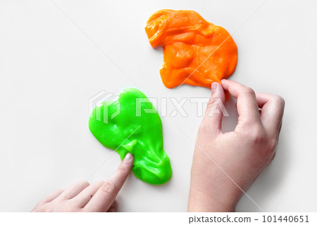 Playing with textured slime with bubbles, stretching the gooey substance. Female teen hand holding blue shining slime, squeezing it. Adorable Girl stretching slime toy to the sides. Liquid toy. 4K 101440651