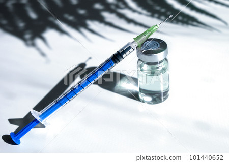 A glass ampoule with a clear liquid with a syringe. Syringe next to the ampoule. Botox glass medicine bottle, Syringe of botulinum toxin, hualuronic, collagen or flu on a white background 101440652