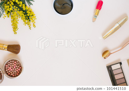 A composition with women's accessories, cosmetics and yellow flowers on a colored background. The concept of a beauty blogger 101441510