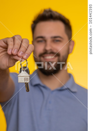 Happy young man real estate agent showing keys of new home house apartment, buying renting property Happy young man real estate agent showing keys of new home house apartment, buying renting property 101441593