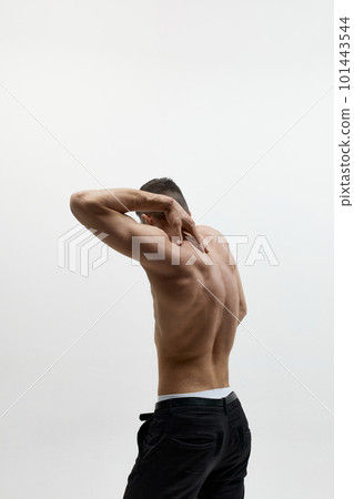 Portrait of muscular male fashion model wearing jeans and posing over studio background. Perfect body shape Portrait of muscular male fashion model wearing jeans and posing over studio background. Perfect body shape 101443544