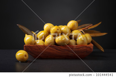 Green olives in wooden dish. 101444541