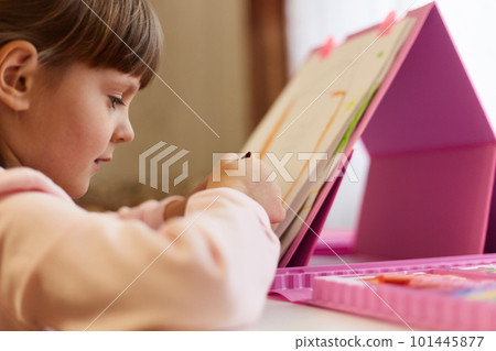 Small cute artist drawing picture while sitting at table, talented female child painting, using art set, dark haired kid girl in casual wear, preschooler little lady. 101445877