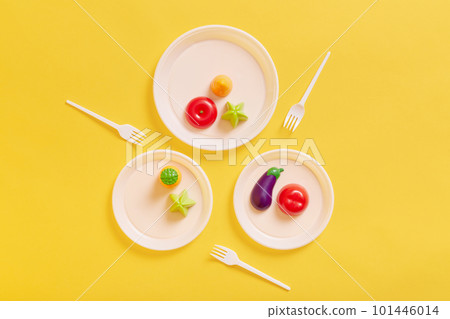 Top view of artificial food on white plates, dishes for three, colorful plastic vegetables, eggplant, carrots, tomatoes, forks to it food with. Top view of artificial food on white plates, dishes for three, colorful plastic vegetables, eggplant, carrots, tomatoes, forks to it food with. 101446014