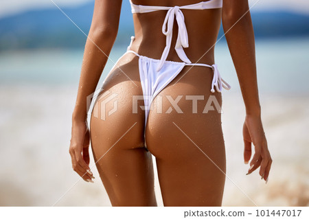 Sexy model's ass in white bikini on the blue water background Sexy model's ass in white bikini on the blue water background 101447017
