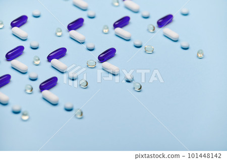 Layout with blue gel translucent capsules with Omega or fish oil, gelatin dragees with fat soluble vitamin D and medical pills arranged in pattern on isolated blue backdrop. Pharma business. Industry Layout with blue gel translucent capsules with Omega or fish oil, gelatin dragees with fat soluble vitamin D and medical pills arranged in pattern on isolated blue backdrop. Pharma business. Industry 101448142