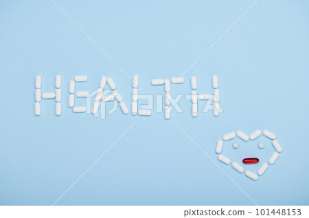 Word HEALTH and heart shape as emoticon laid out with medical therapeutic pills and translucent gel capsules, on isolated blue background. World Health Day. Pharmaceutical industry concept. Copy space Word HEALTH and heart shape as emoticon laid out with medical therapeutic pills and translucent gel capsules, on isolated blue background. World Health Day. Pharmaceutical industry concept. Copy space 101448153