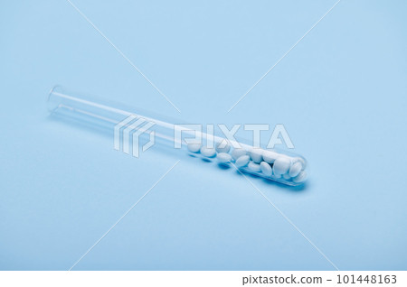 Medical blue colored pills in a laboratory test tube on isolated blue background. Prescription medicines. Healing dragees. Painkiller. Healthcare and medicine. Pharma business. Copy advertising space 101448163