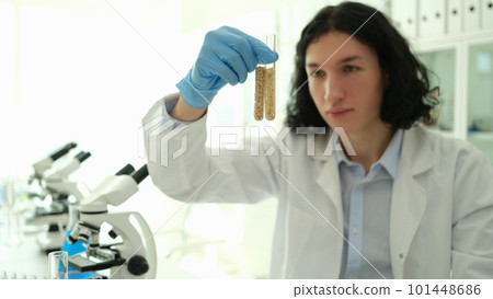 Chemist scientist holding test tubes with grains in laboratory closeup 101448686