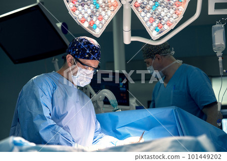 Portrait of a male surgeon in the operating room on the background of modern surgery and lighting devices, a modern operating room, hard work of a doctor. 101449202