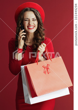woman against background with shopping bags talking on phone 101449294