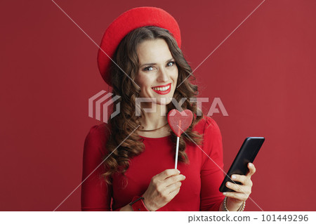 woman on background with heart shaped candy using phone woman on background with heart shaped candy using phone 101449296