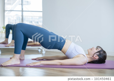 Young woman doing Pilates hip rolls 101450461