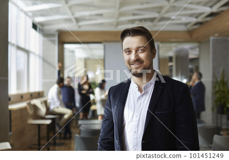 Portrait of smiling male executive director against background of office and workers. 101451249