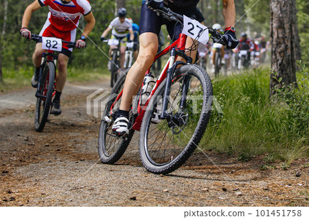 group mountainbikers riding cross-country cycling competition,  race in forest trail 101451758