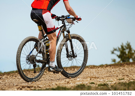 close-up mountainbiker biking uphill in cross-country cycling, outdoors summer race close-up mountainbiker biking uphill in cross-country cycling, outdoors summer race 101451782