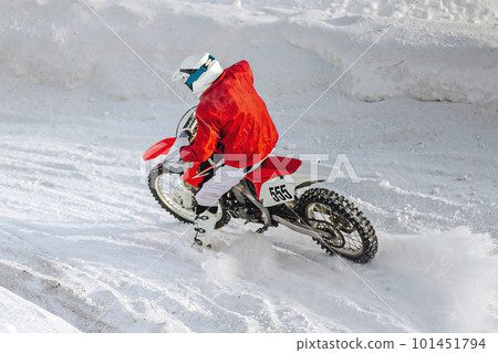 motocross rider riding sharp turn winter motorcycle racing, snow splashes from under rear wheel motocross rider riding sharp turn winter motorcycle racing, snow splashes from under rear wheel 101451794