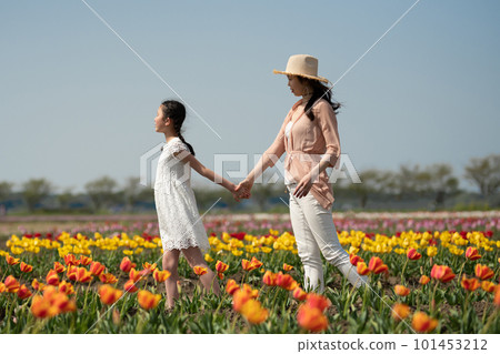Parent and child playing in flower garden Parent and child playing in flower garden 101453212