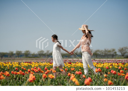 Parent and child playing in flower garden Parent and child playing in flower garden 101453213