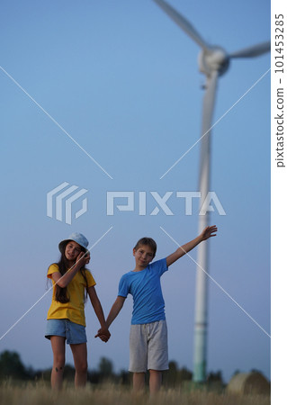 School boy stand on the wind farm. Wind turbines alternative electricity sources. Future of kid and sustainable resources. People in the community with wind generators turbines. Selective focus 101453285